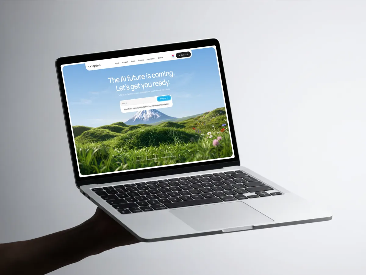 A laptop held in one hand showing the Topdevs hero: The AI future is coming. Let's get you ready.